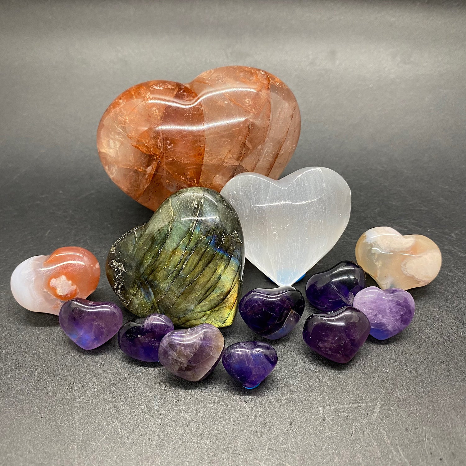 cluster of crystal hearts displayed; crystal hearts include flower agate, labradorite, selenite, fire quartz, and amethyst