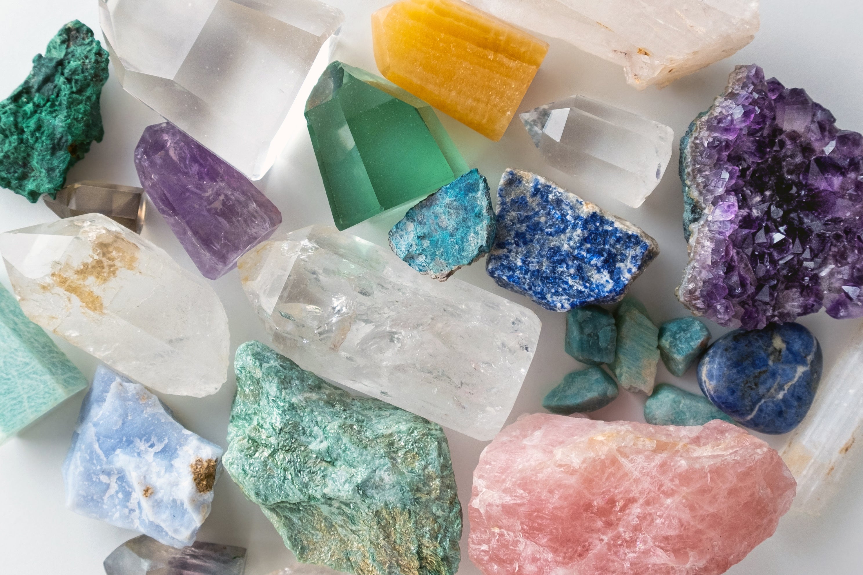Top view of various crystals and gemstones on white background