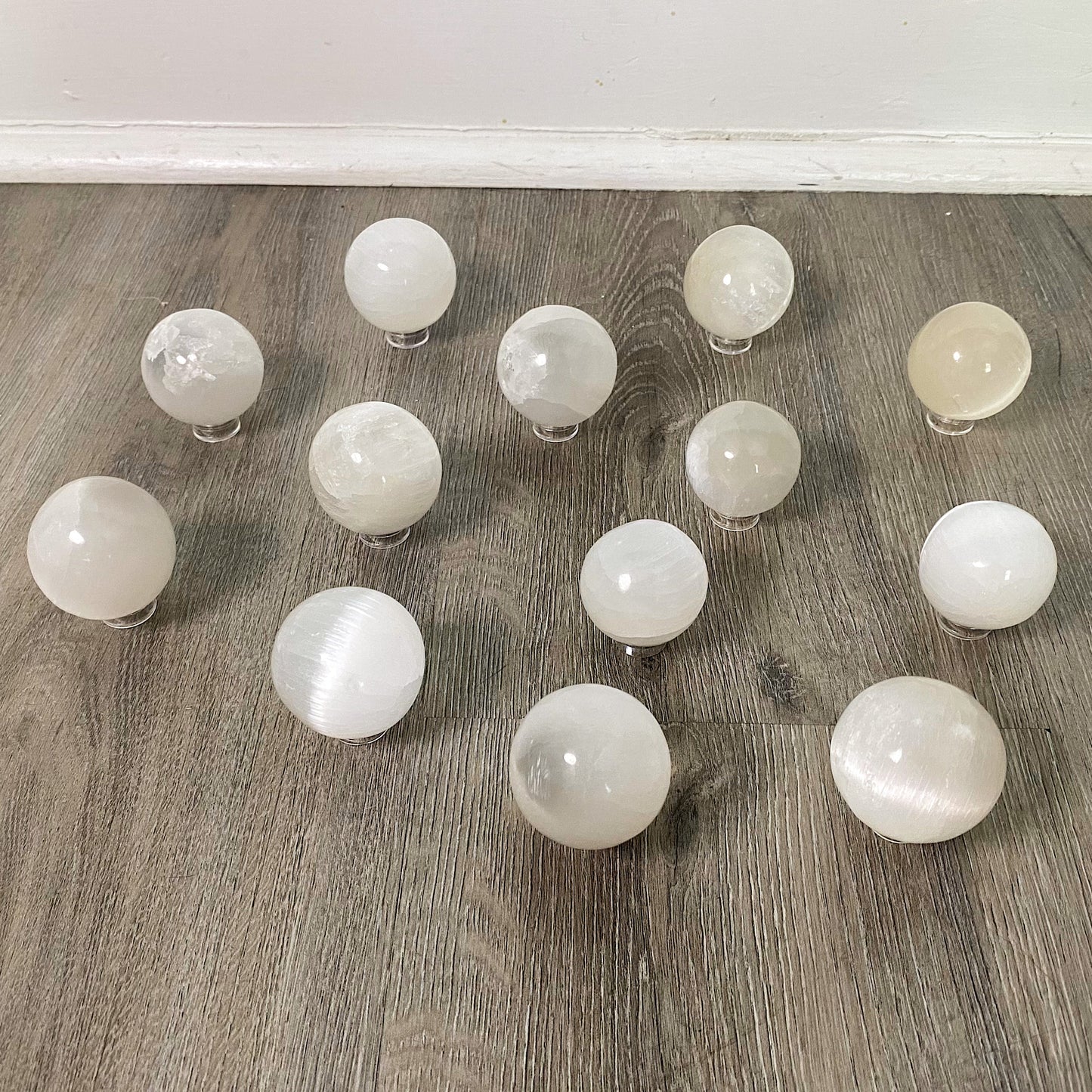 group of selenite spheres on stands on wood background